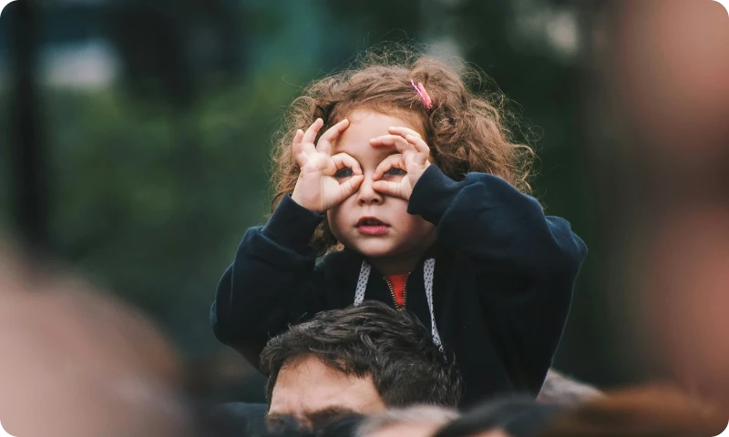 child sitting on shoulders of an adult